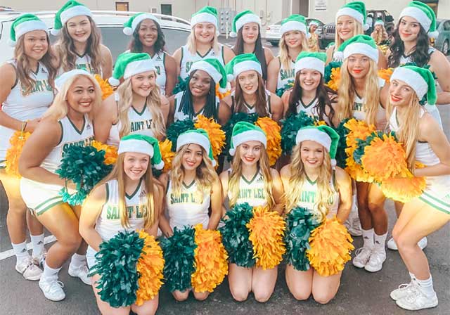 Saint Leo University cheerleading team with green Santa hats for holiday parade